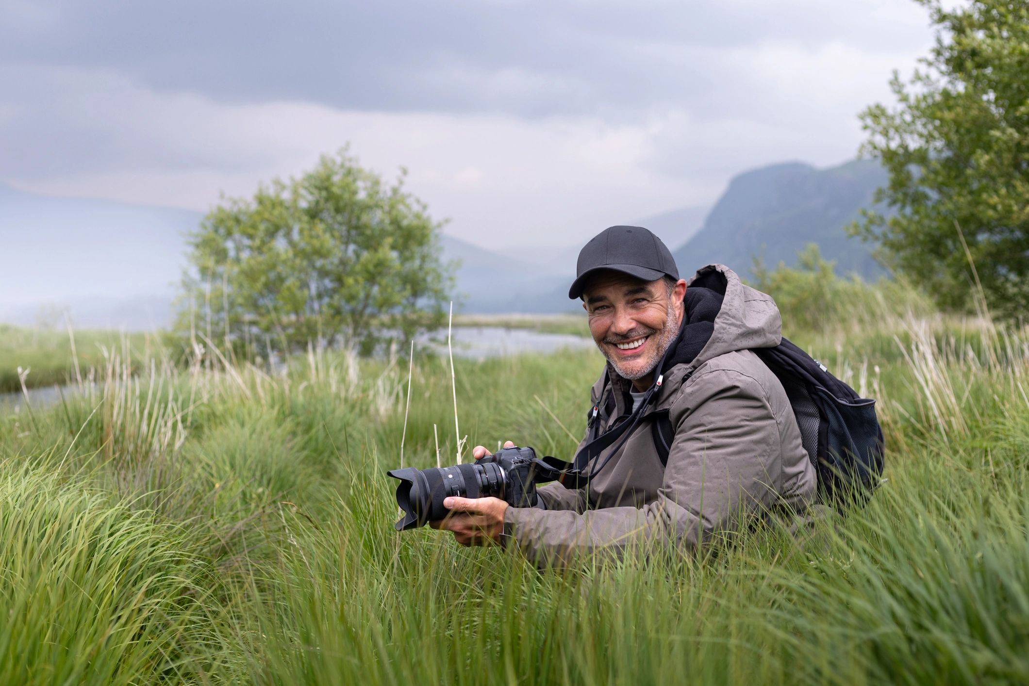 Professional photographer holding a camera outdoors