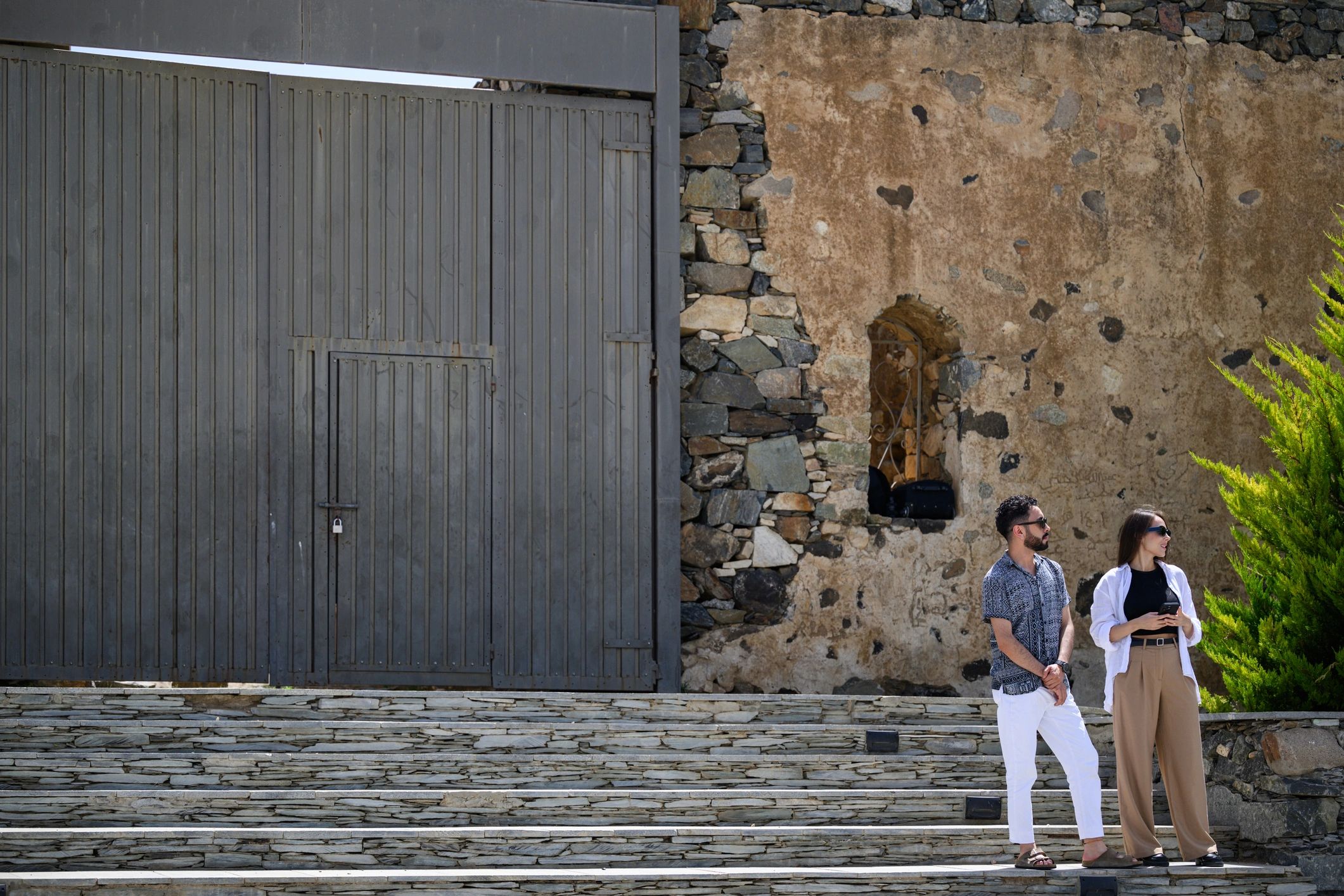 Couple standing together near a historic stone wall